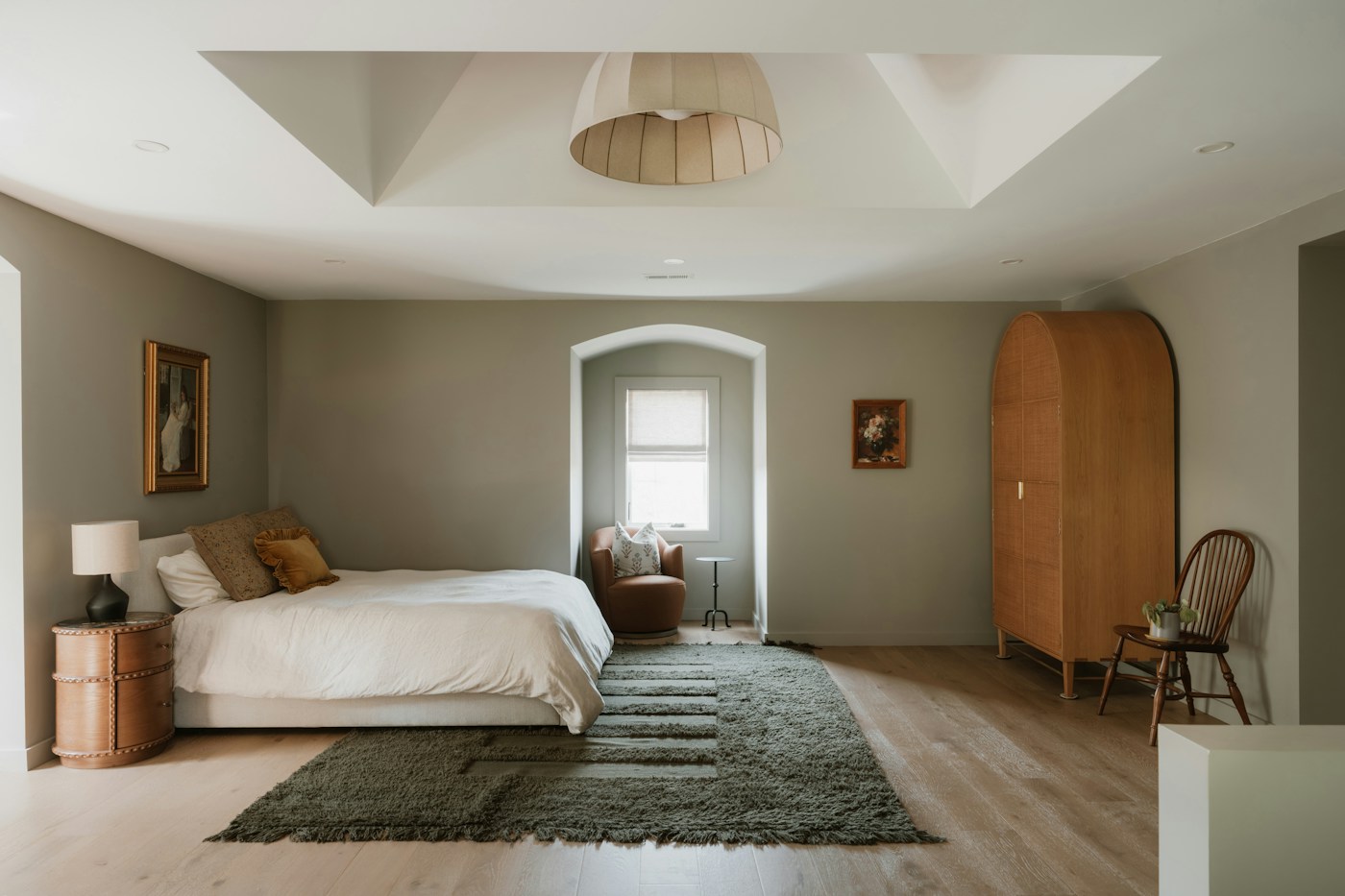 Warm bedroom with natural light, a large bed and a timber wardrobe